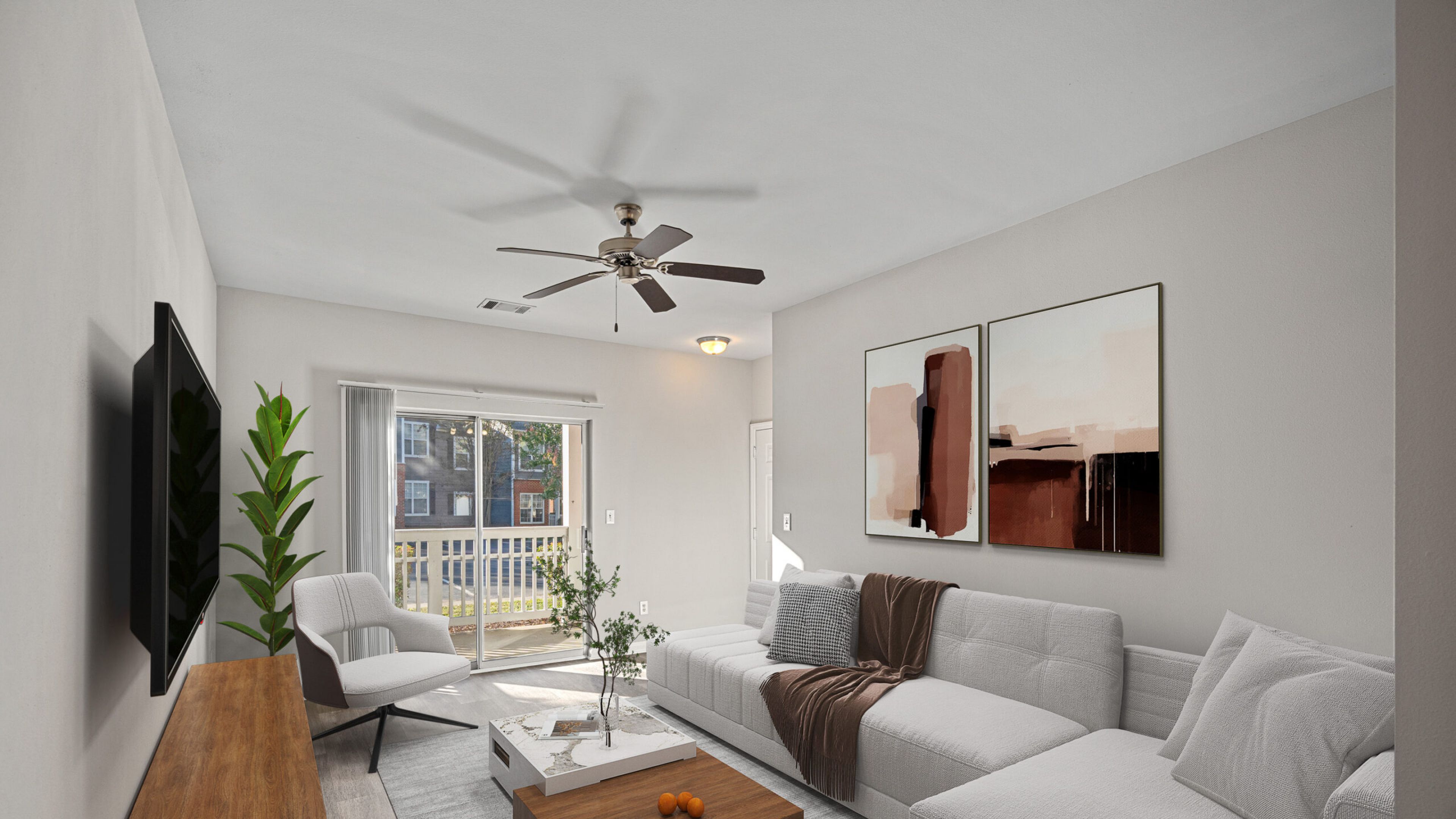 Modern living room with a white sectional sofa, large abstract art, TV, and sunlight streaming through glass doors.