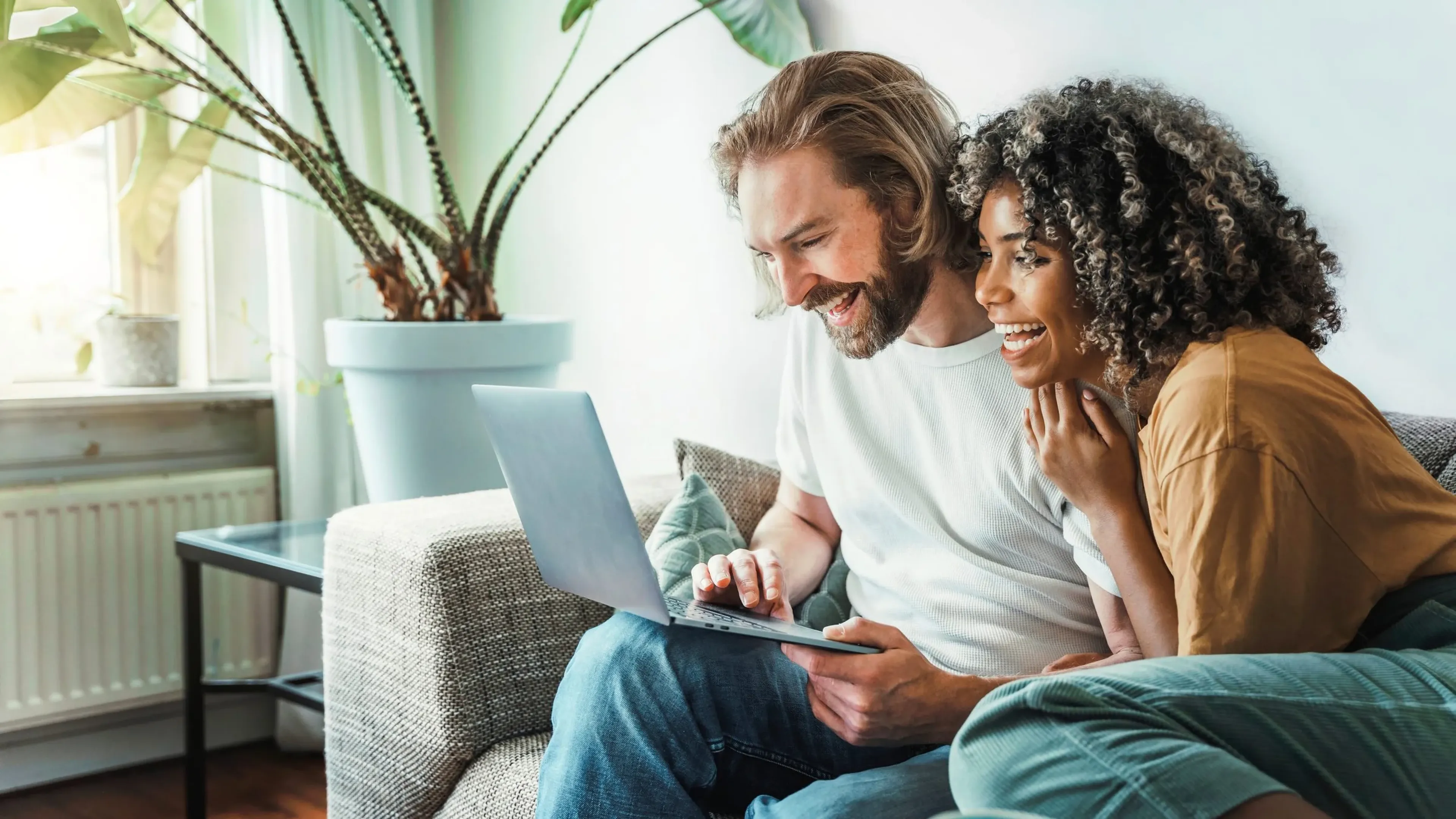 Couple smiling while looking at laptop